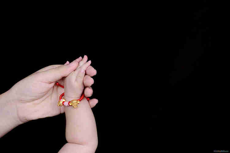 bàn tay của mẹ và em bé trên nền màu đen