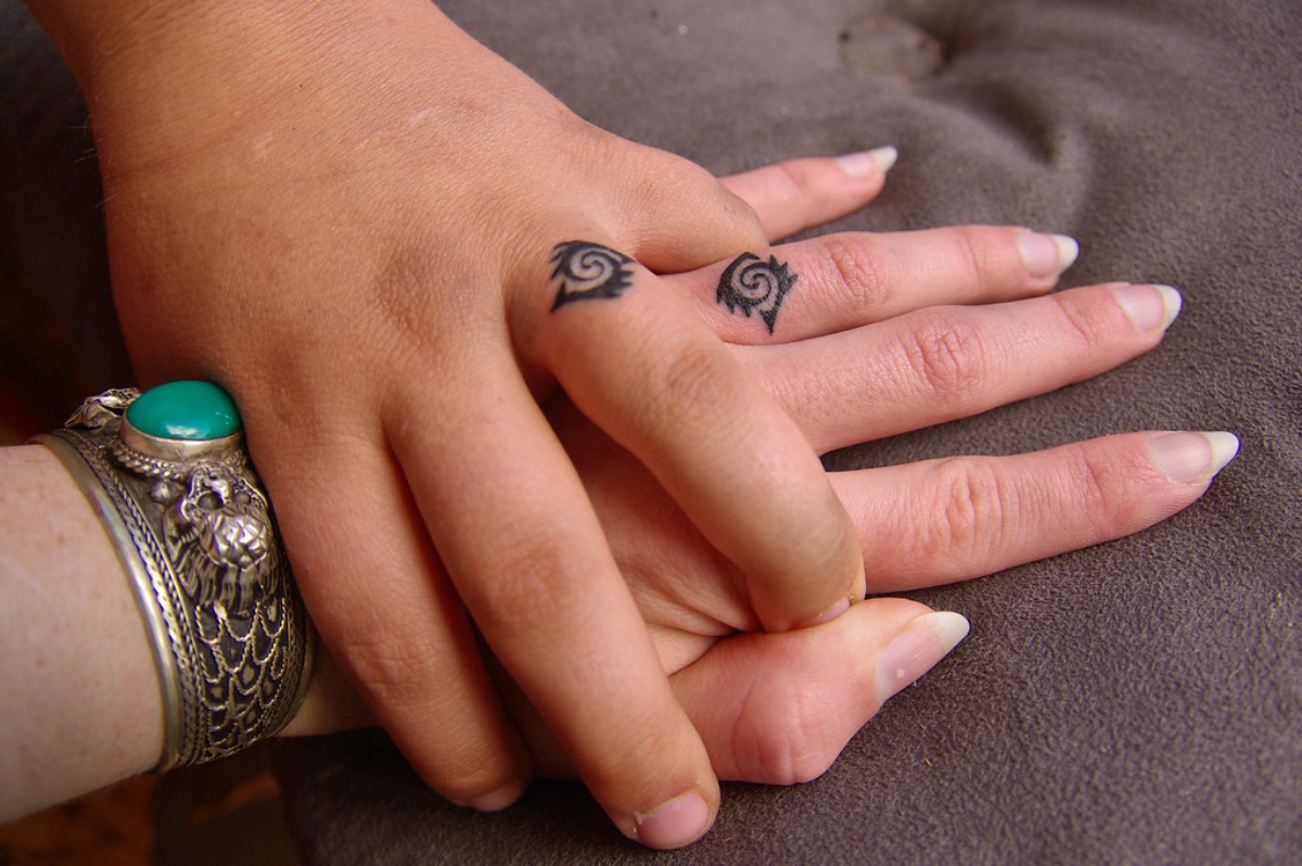 Una pareja con dos anillos tatuados