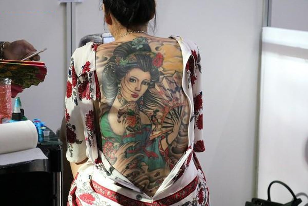Cô gái và chiếc quạt được khắc họa rõ nét trên tattoo kín lưng